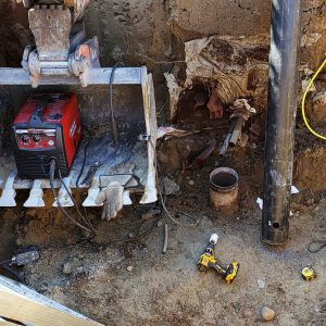 Cleaning out the well pit and extending the well above grade.